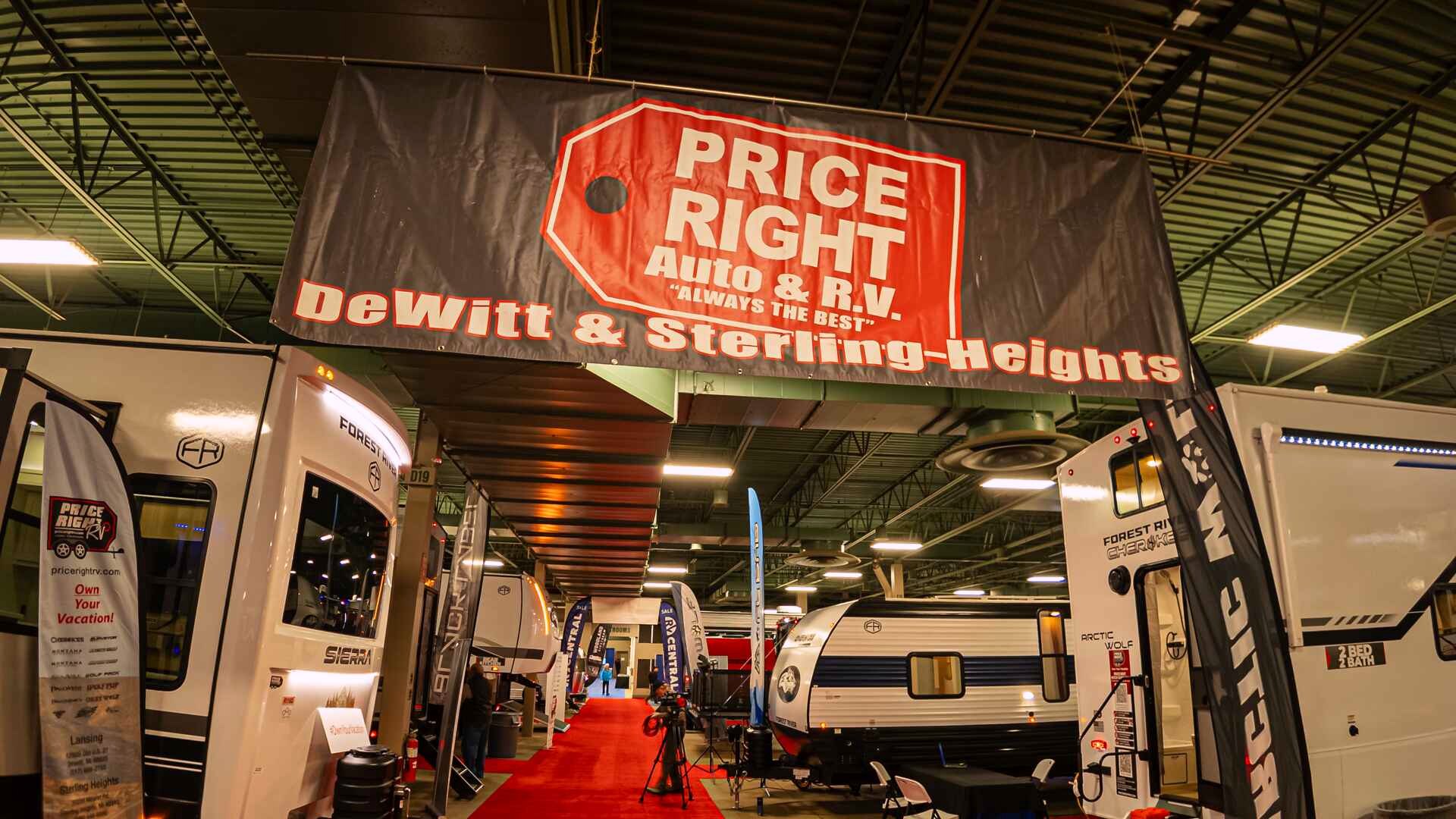 Price Right RV banner above a red-carpet aisle lined with RVs at the 2026 Lansing show.